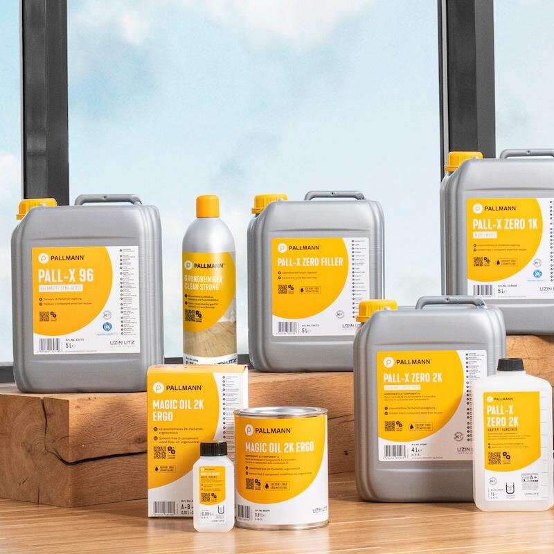 Produktübersicht der Marke PALLMANN. Produktflaschen und Kanister sind auf Parkettboden nebeneinander angeordnet.